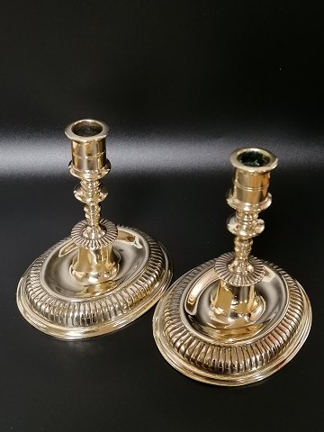 A pair of brass candlesticks on an oval base